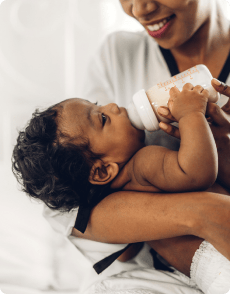 Woman giving a baby milk using bottle