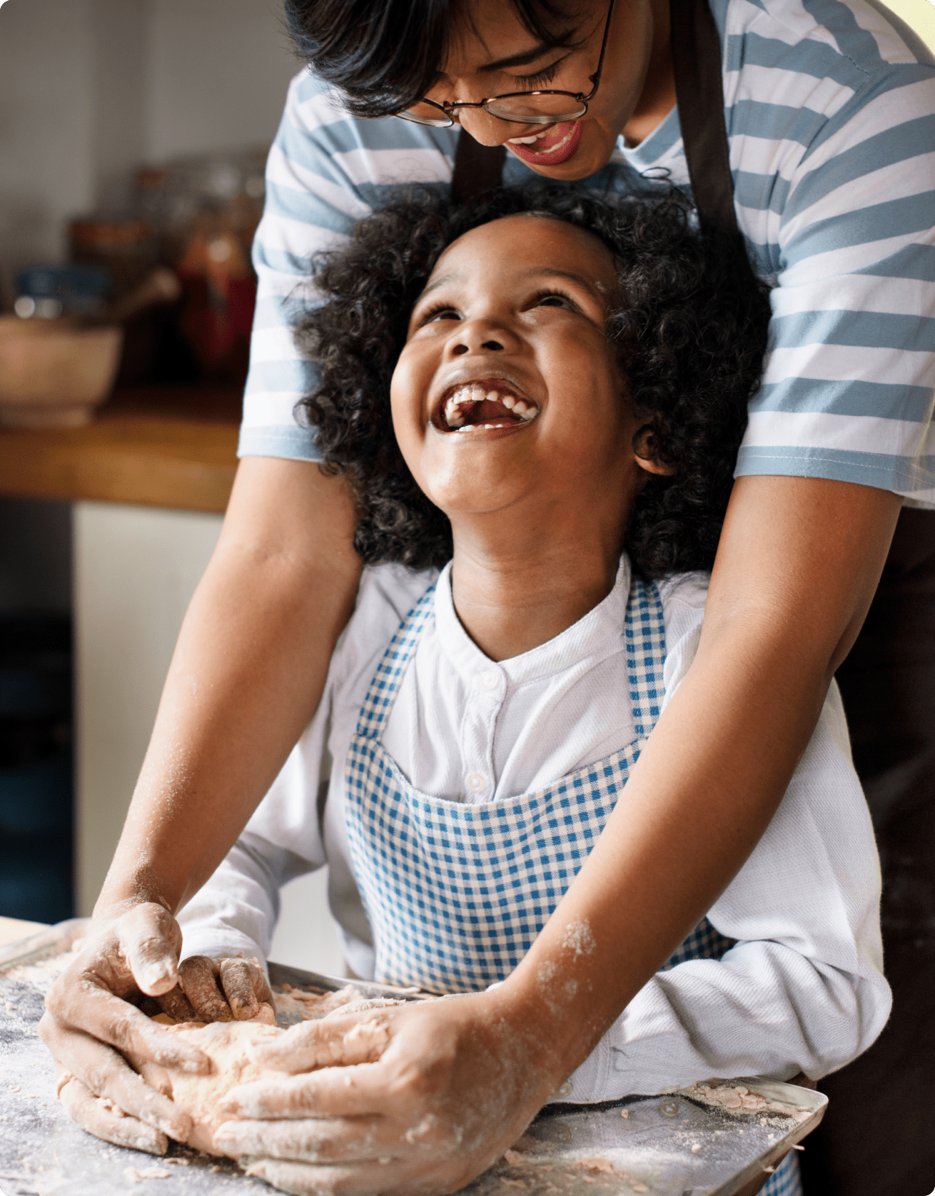 Close up of kid laughing while making dough with father